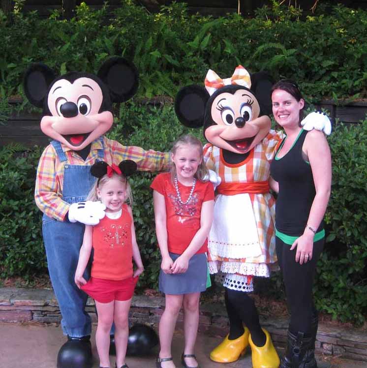 Family posing around Mickey and Minnie Mouse